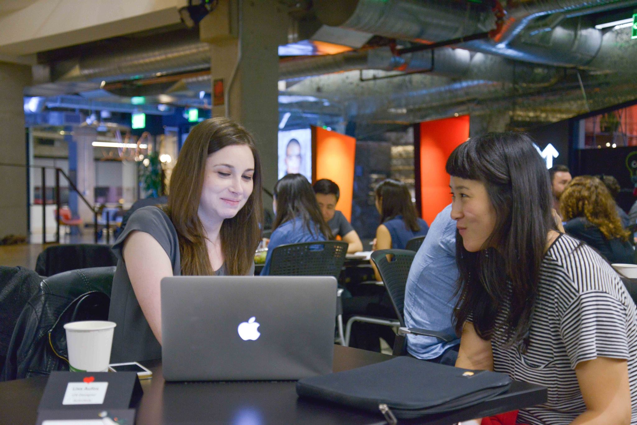 A mentor reviewing a designer's portfolio together on a laptop at a Cascade SF mentor night