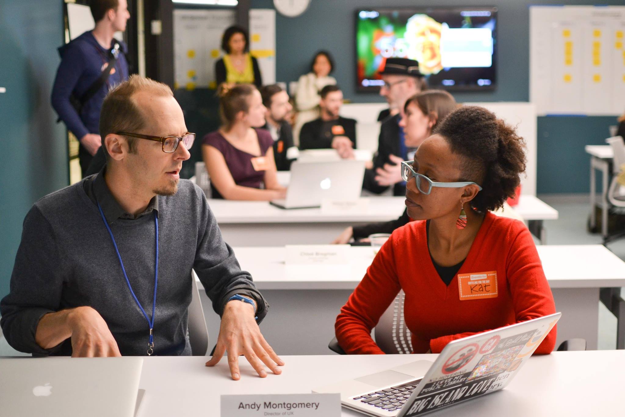 Two designers deep in conversation across a table during Mentor Night