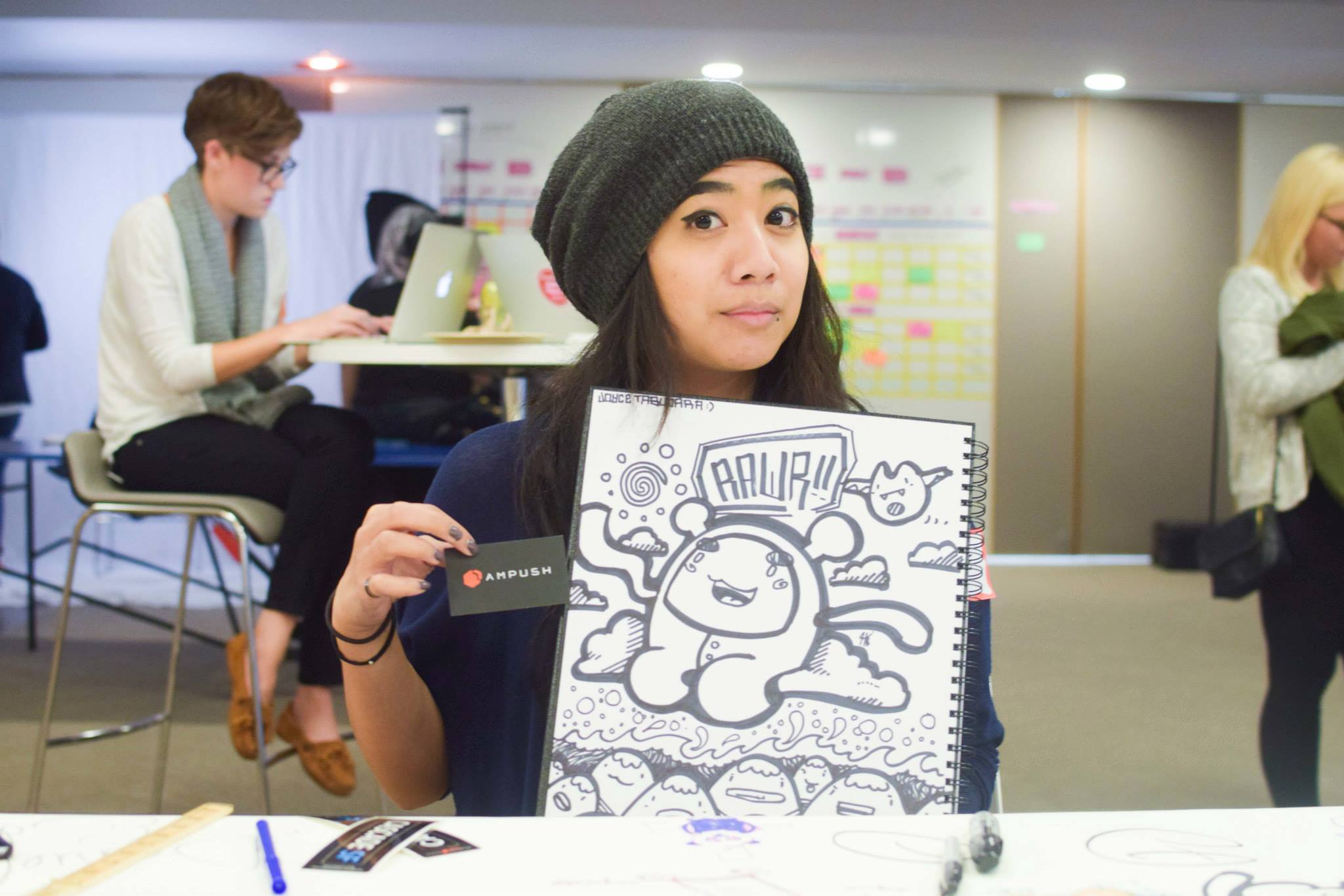 A workshop attendee holding up a sketchbook drawing she made during the session